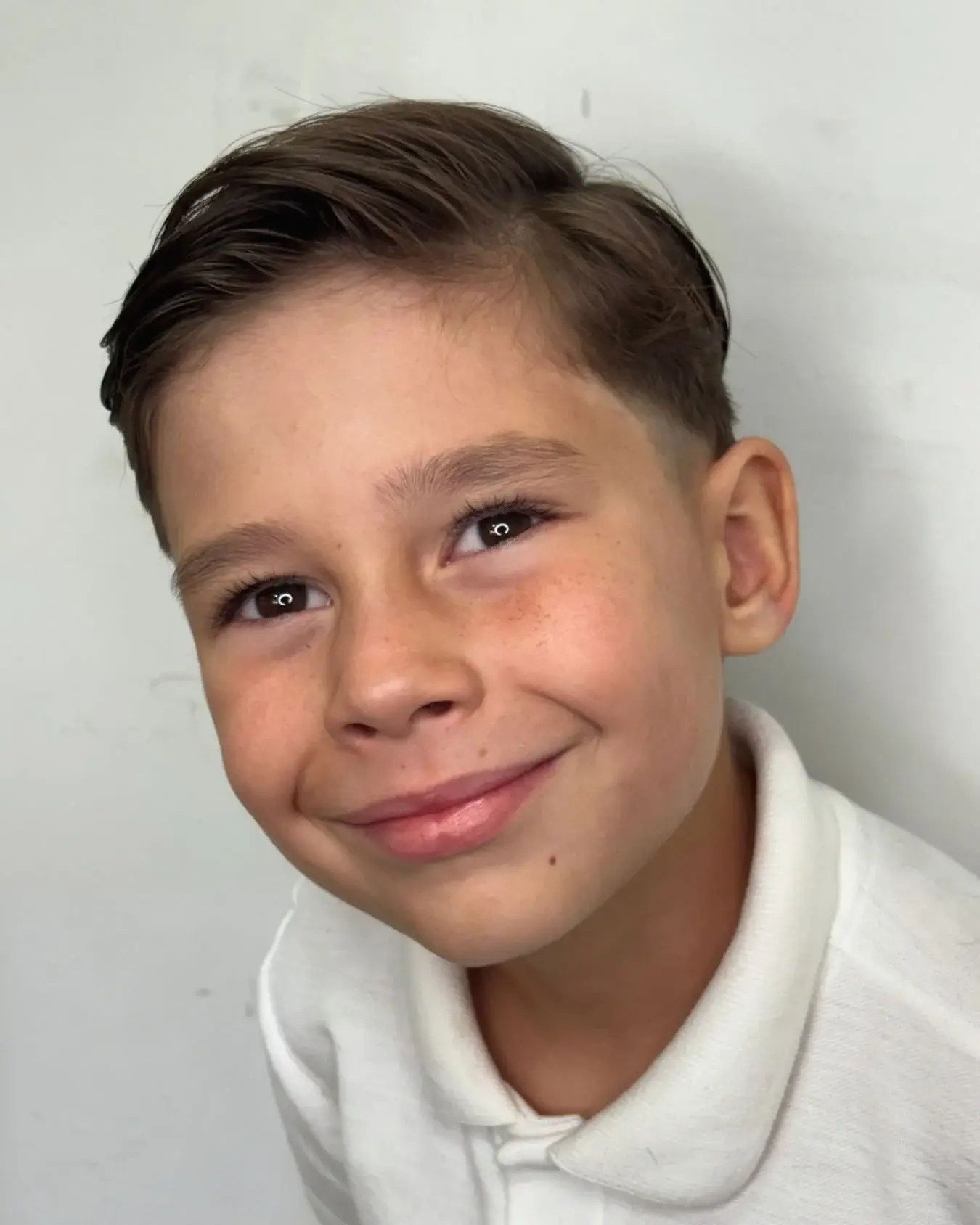 Menino sorrindo com o corte finalizado no LF Kids